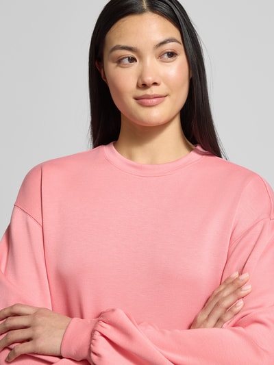 Vrouwenmodel draagt oversized sweatshirt met geribde boorden van MSCH Copenhagen, model 'Brionna', roze, viscosemix. Nahaufnahme bovenlichaam.