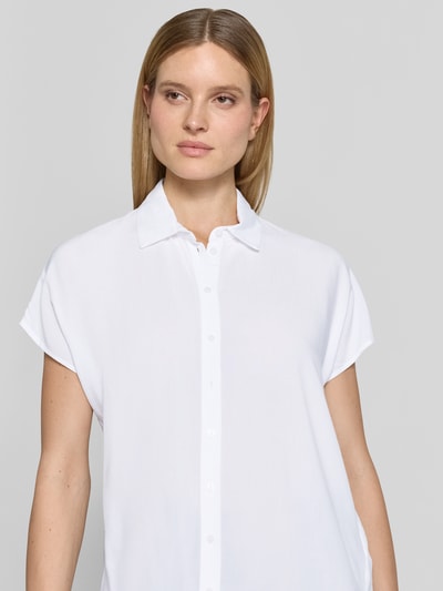 Frauenmodel trägt Regular Fit Bluse aus Viskose von Christian Berg Woman in Weiß mit Hemdblusenkragen und Knopfleiste, Nahaufnahme Oberkörper. Rückenlänge bei Größe 36: 64 cm, Ärmellänge: 15 cm.