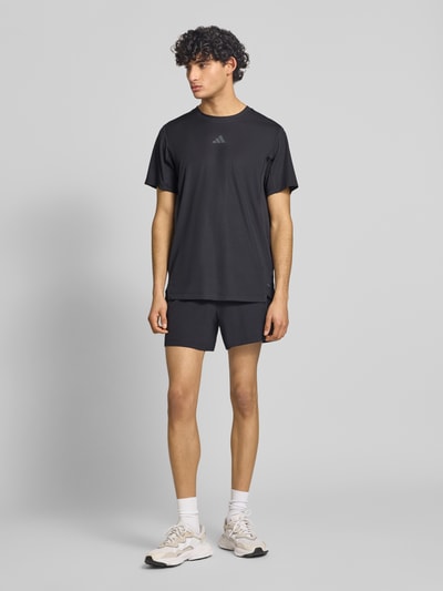 Männermodel trägt Regular Fit Sport T-Shirt mit Label Print von adidas Training, Optik: Unifarben, Materialverarbeitung: Stretch-Webstruktur, Ganzkörperansicht von vorne.