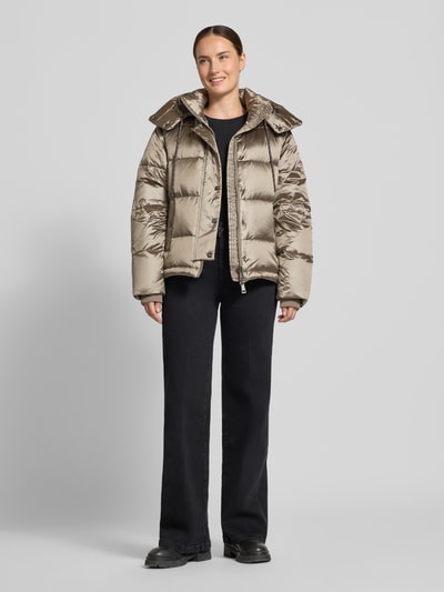 Kobieta modelka ma na sobie kurtkę Regular Fit Jacke mit Daunen-Feder-Füllung Modell 'Jilly' od MOS MOSH, Wypełnienie z puchu i pierza, z efektem pikowania, kaptur z tunelem, długość tyłu w rozmiarze S: 62 cm, szerokość ramion w rozmiarze S: 47 cm, szerokość klatki piersiowej w rozmiarze S: 54 cm, długość rękawów w rozmiarze S: 65 cm, jasnobeżowe i czarne tony, matowa tekstura, przód pełnej sylwetki