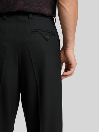 Männermodel trägt Regular Fit Anzughose mit Bügelfalten Modell 'FLIPS251X' von HUGO in Schwarz, Stretch-Twill, Detailaufnahme Rückansicht.