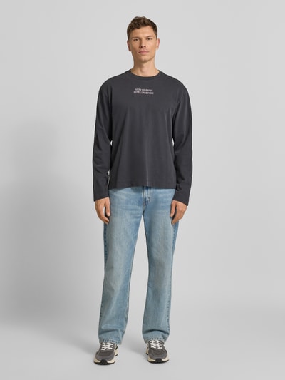 Männermodel trägt Sweatshirt mit Rundhalsausschnitt Modell 'Ryan' von Wood Wood, reine Baumwolle, lockerer Schnitt, Ganzkörperansicht von vorne.