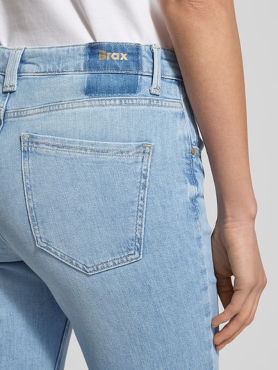 Frauenmodel trägt Flared Jeans mit Eingrifftaschen Modell 'Mary' von BRAX, hellblaue Denim-Optik, Bundweite bei Größe 36: 41 cm, Nahaufnahme Rückansicht.
