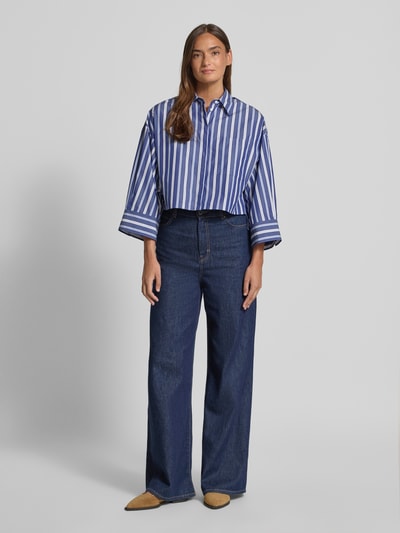 Vrouwenmodel draagt Boxy Fit Hemdbluse aus reiner Baumwolle Modell 'VELOCE' van MAX&Co., blauw-wit gestreept all-over motief, borstzak, lange mouw met wijde manchet, knoopsluiting, puur katoen, overhemkraag, achterpas met lus, boxy fit, voorkant hele lichaam van voren.