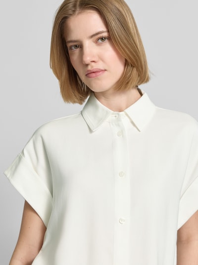 Frauenmodel trägt Boxy Fit Bluse aus Viskose-Mix Modell 'Zelya' von Someday in Elfenbein, glatte Textur, Hemdblusenkragen, Nahaufnahme Oberkörper.