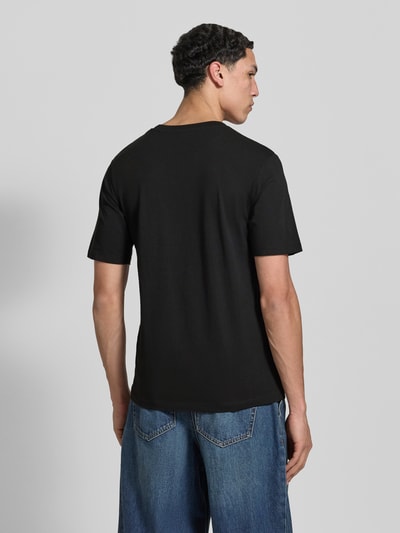 Männermodel trägt T-Shirt aus Bio-Baumwolle Modell 'NANTUCKET' von Jack & Jones, reine Baumwolle, schwarze Farbe, gerader Schnitt, Ganzkörperansicht Rückansicht.