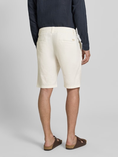Männermodel trägt Tapered Chinoshorts aus Leinen-Mix Modell 'DS_3S' von BOSS Orange in Beige mit elastischem Bund und Paspeltaschen, Ganzkörperansicht Rückansicht.