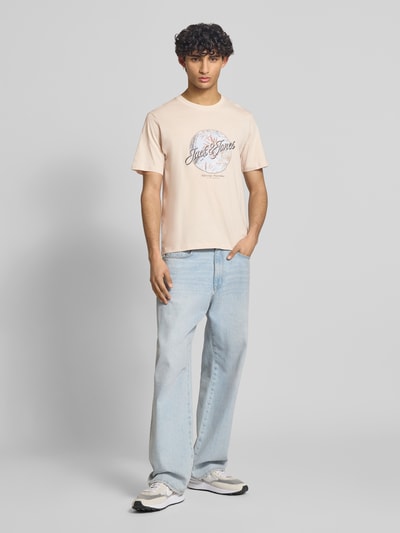 Männermodel trägt Herren T-Shirt mit Print, Regular-Fit, Reine Baumwolle, T-Shirt mit Rundhalsausschnitt Modell 'HONOLULU' von Jack & Jones, helle Farben, glatte Textur, Rückenlänge bei Größe M 68 cm, Ganzkörperansicht von vorne.