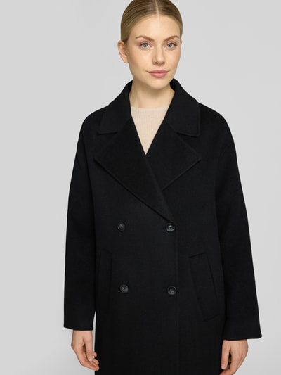 Modelka kobieca nosi czarny Relaxed Fit Mantel aus reiner Wolle mit 2-Knopfleiste od Milano Italy, z szerokim kołnierzem, kieszenie z przodu, tekstura gładka, widoczne dwa guziki, długość do kolan, szerokość w rozmiarze 36: 56 cm, długość rękawa: 55 cm, szerokość ramion: 45 cm, długość pleców: 115 cm, widok z przodu, zbliżenie na górną część ciała.