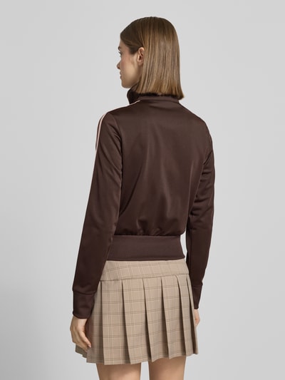 Frauenmodel trägt Regular Fit Sweatjacke mit Logo-Stitching von adidas Originals in Braun, Kontraststreifen, Stehkragen, Ganzkörperansicht Rückansicht