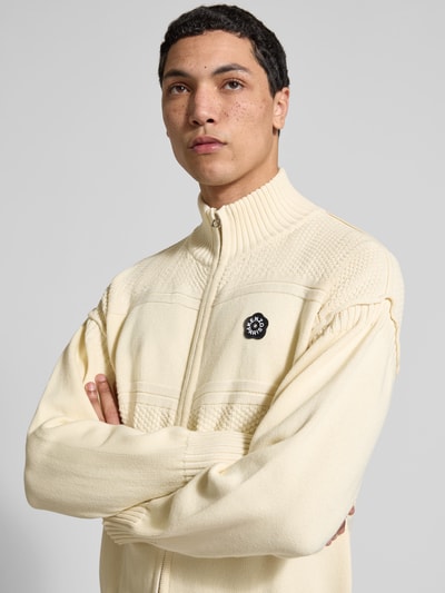 Männermodel trägt Relaxed Fit Strickjacke mit Woll-Anteil von Kenzo in Hellbeige, Baumwoll-Woll-Mix, Label-Patch, Nahaufnahme Oberkörper.