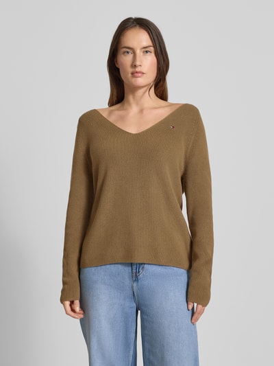 Kobiece model prezentuje Regular Fit Strickpullover aus reiner Baumwolle od Tommy Hilfiger, brązowy, długi rękaw, dekolt w serek, przód z logo, widok z przodu, zdjęcie całej sylwetki.