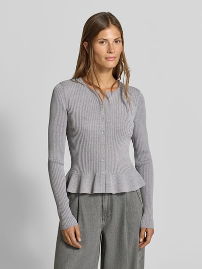 Frauenmodel trägt Strickjacke aus Viskose-Mix von MYON, körpernahe Passform, grau, Ripp-Optik, Rüschenbund, Ganzkörperansicht von vorne.