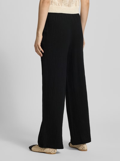 Frauenmodel trägt Loose Fit Weite Hose aus reiner Baumwolle Modell 'THYRA' von Only, unifarben, elastischer Bund, Flammgarn, Ganzkörperansicht Rückansicht.