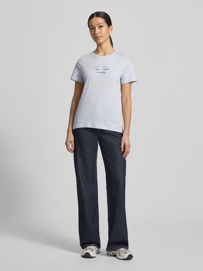 Frauenmodel trägt Regular Fit T-Shirt aus Bio-Baumwoll-Mix von Tom Tailor, unifarben, Rundhals, kurzarm, Label-Schriftzug, Ganzkörperansicht von vorne.