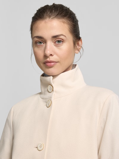 Frauenmodel trägt Regular Fit Jacke mit Stehkragen von WHITE LABEL in Beige aus mieszanka bawełny, nakładane kieszenie, listwa guzikowa, Nahaufnahme Oberkörper. Długość tyłu w rozmiarze 36: 57 cm, szerokość w rozmiarze 36: 50 cm, długość rękawów w rozmiarze 36: 65 cm.