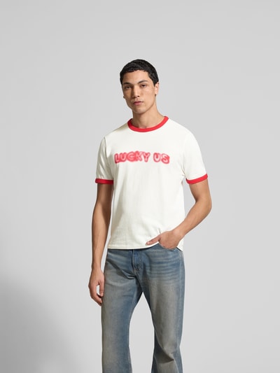 Männermodel trägt Regular Fit T-Shirt aus reiner Baumwolle von Kenzo, Rundhalsausschnitt, Statement-Print, kurzärmelig, Ganzkörperansicht von vorne. Herren T-Shirt, Rückenlänge bei Größe M 64 cm, weiß mit roten Akzenten.