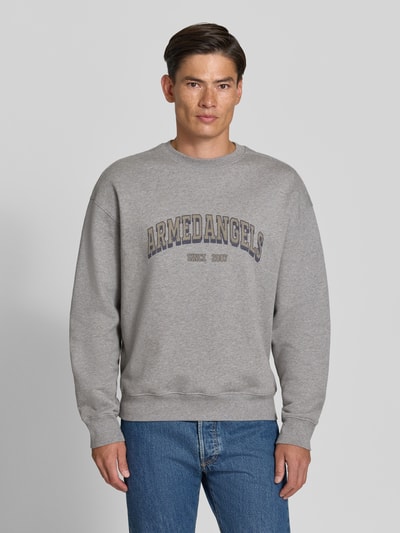 Männermodel trägt graues Relaxed Fit Sweatshirt aus reiner Baumwolle Modell 'WORDMARK' von ARMEDANGELS, Herren Sweatshirt, Ganzkörperansicht von vorne.