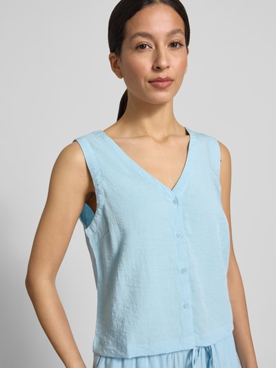 Modelka kobieca nosi Regular Fit Bluse Aus Viskose-Mix Modell 'Daria' od MSCH Copenhagen, bez rękawów, V-dekolt, krój regular fit, niebieski, mieszanka wiskozy i lnu, długość tyłu 49 cm w rozmiarze S, zapięcie na guziki, faktura lekko marszczona, zbliżenie na górną część ciała z przodu.