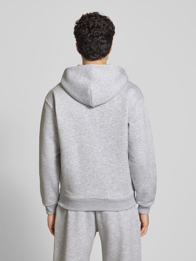 Männermodel trägt Sweatjacke mit Känguru-Tasche von REVIEW aus Baumwoll-Mix im Relaxed-Fit, Rückenlänge 68 cm, Ganzkörperansicht Rückansicht.