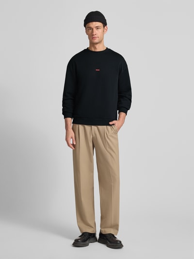 Männermodel trägt Regular Fit Sweatshirt aus reiner Baumwolle Modell 'DUBRAXO' von HUGO, unifarben, Rundhals, Ganzkörperansicht von vorne.
