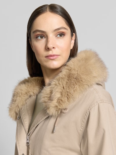 Kobiece model prezentuje Regular Fit Parka aus reiner Baumwolle von Marc O'Polo w jasnobeżowym kolorze, wyraźna faktura, detal kołnierza z futrem, zbliżenie na górną część ciała.
