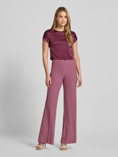 Vrouwenmodel draagt Flared Fit Hose met bandplooien van Rinascimento in paars, elastische materiaalmix, naadritssluiting, bandwijdte maat S 37 cm, binnenbeenlengte maat S 85 cm, full body vooraanzicht.