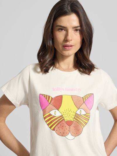 Modelka kobieca ma na sobie T-Shirt mit Motiv-Print Modell 'Roma' od LOLLYS LAUNDRY, czysta bawełna, krój regular fit, dekolt okrągły, przód z kolorowym nadrukiem kota, długość pleców w rozmiarze S: 61 cm, jasne kolory, miękka tekstura, zbliżenie na górną część ciała frontalnie.