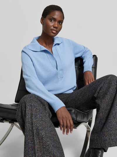 Frauenmodel trägt Relaxed Fit Pullover aus Woll-Mix von Victoria Beckham in Hellblau, Strick-Optik, Umlegekragen, V-Ausschnitt, Nahaufnahme Oberkörper.