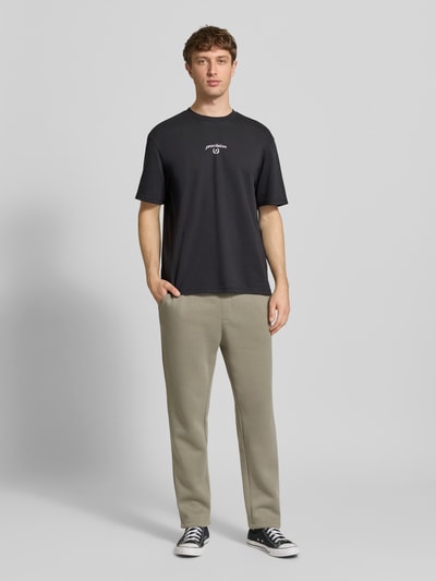 Männermodel trägt Regular Fit T-Shirt aus Baumwoll-Mix Modell 'CASPIAN' von Only & Sons, Optik: Unifarben, Schriftzug, Rundhals, Kurzarm, Ganzkörperansicht von vorne.