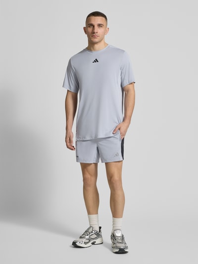 Männermodel trägt Regular Fit Sport T-Shirt mit Label Print von adidas Training, Unifarben, Stretch-Webstruktur, Ganzkörperansicht von vorne.