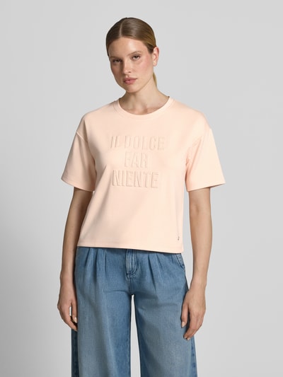 Frauenmodel trägt Regular Fit Sweatshirt mit Viskose-Anteil von monari in zartem Rosaton, Statement-Besatz, Rundhalsausschnitt, Halbarm, Elastischer-Material-Mix, Ganzkörperansicht von vorne.