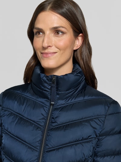 Kobieta nosi Steppmantel mit Zweiwege-Reißverschluss von Christian Berg Woman Selection w kolorze granatowym, krój slim fit, kaptur z troczkiem, tekstura pikowana, szerokość w rozmiarze 36: 48 cm, długość tyłu: 83 cm, szerokość ramion: 40 cm, długość rękawa: 65 cm, zbliżenie na górną część ciała