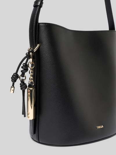 Produktfoto, czarna torebka typu bucket bag z aplikacją z logo, model 'Roxie' od Furla, główna przegroda z zapięciem na magnes, regulowany pasek na ramię, przegródka zapinana na zamek błyskawiczny, szerokość w rozmiarze 1: 24 cm, długość w rozmiarze 1: 26 cm, głębokość w rozmiarze 1: 17 cm, długość paska w rozmiarze 1: 67 cm