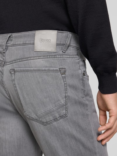 Männermodel trägt Straight Fit Jeans mit 5-Pocket-Design Modell 'Chuck' von Brax aus grauem Baumwoll-Mix mit Stretch-Anteil, Detailaufnahme Rückansicht.