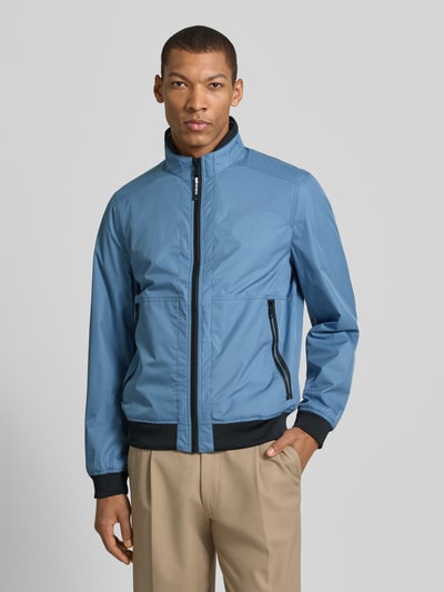 Männermodel trägt Regular Fit Jacke mit Stehkragen von MCNEAL in Blau mit Reißverschluss, Eingrifftaschen, elastische Abschlüsse, Ganzkörperansicht von vorne. Rückenlänge 64 cm, Schulterbreite 43 cm, Brustweite 55 cm, Ärmellänge 67 cm.