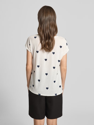 Frauenmodel trägt Relaxed Fit T-Shirt aus Lyocell-Mix Modell 'AVA' von Vero Moda mit Allover-Herzprint, Kurzarm, Rückansicht.