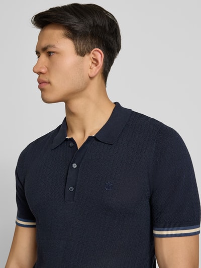 Männermodel trägt Slim Fit Poloshirt mit Strukturmuster und Knopfleiste von Superdry, Reine Baumwolle, Dunkelblau, Nahaufnahme Oberkörper.