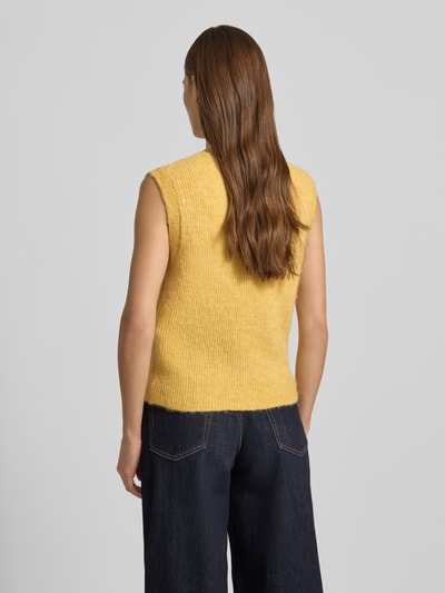 Modelka kobieca ma na sobie Regular Fit Strickjacke aus Woll-Mix od Selected Femme, żółty, dzianina, jednolita, bez rękawów, widok całej sylwetki od tyłu.