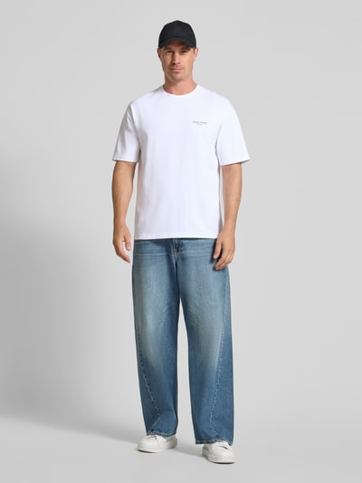 Männermodel trägt T-Shirt mit Label-Stickerei Modell 'Sauni' von Samsøe Samsøe, reine Baumwolle, gerader Schnitt, Ganzkörperansicht von vorne.