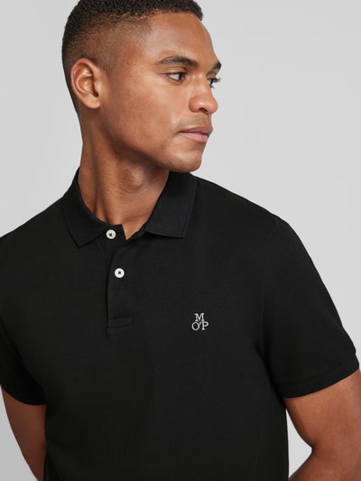Męski model nosi Poloshirt mit fein strukturierter Optik od MARC O’POLO, czarne, bawełna, logo z przodu, unicolor, tkanina teksturowana, zbliżenie na górną część ciała
