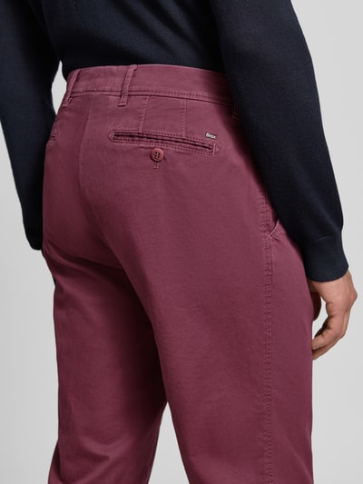 Männermodel trägt Regular Fit Chino aus Baumwoll-Mix Modell 'Evans' von Brax in Unifarbe, Twillstruktur, Nahaufnahme Rückansicht.