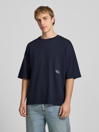 Männermodel trägt T-Shirt mit Stitching und Rundhalsausschnitt von REVIEW in Dunkelblau, reine Baumwolle, oversized, Ganzkörperansicht von vorne.