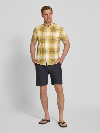 Mannenmodel draagt Slim Fit Freizeithemd met Logo-Stitching van camel active, geel geruit, katoen, borstzak, korte mouw, button-down-kraag, volledige knoopsluiting, slim fit, vooraanzicht volledige lichaamsopname.