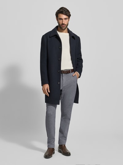 Mannenmodel draagt Relaxed Fit Schmale Hose aus reiner Baumwolle Modell 'HARLEM' van Tommy Hilfiger, unikleurig two tone, regular lengte, label stitching en logo details, knoop- en ritssluiting, elastische taille, zijzakken en achterzakken, katoentextuur, full body vooraanzicht.