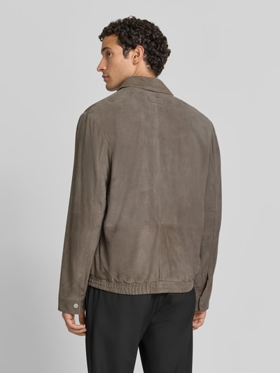 Männermodel trägt Regular Fit Lederjacke aus echtem Ziegenleder von Marc O'Polo in Grau, glatte Textur, Ganzkörperansicht Rückansicht.