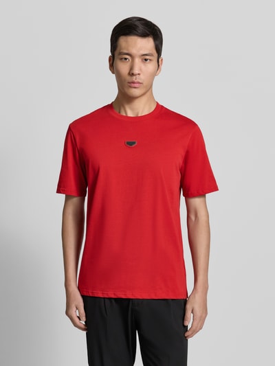 Männermodel trägt T-Shirt mit Label-Detail von Antony Morato in Rot, reine Baumwolle, Regular Fit, gerippter Rundhalsausschnitt, Ganzkörperansicht von vorne.