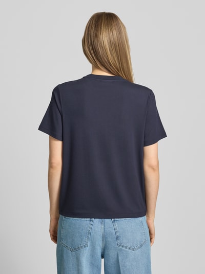 Frauenmodel trägt T-Shirt aus Viskose-Mix mit Pailletten von Comma in Dunkelblau mit Strukturmuster, Regular-Fit, Rückenlänge 56 cm, Ganzkörperansicht Rückansicht.