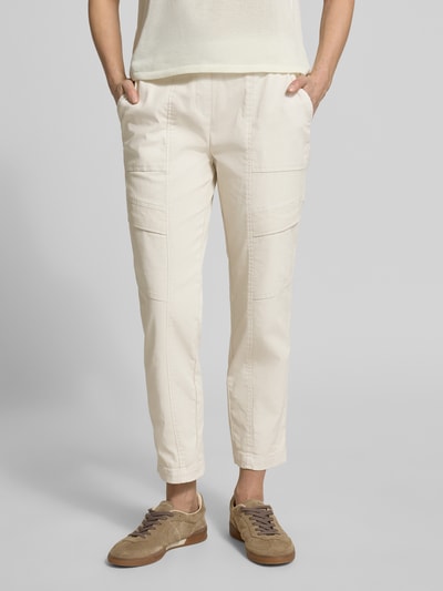 Frauenmodel trägt Cargohose mit Pattentaschen Modell 'SUE' von TONI in Creme, Baumwoll-Mix mit Stretch-Anteil, verkürzte Passform, elastischer Bund mit Kordelzug, französische Eingrifftaschen, Gesäßtaschen, Ganzkörperansicht von vorne.