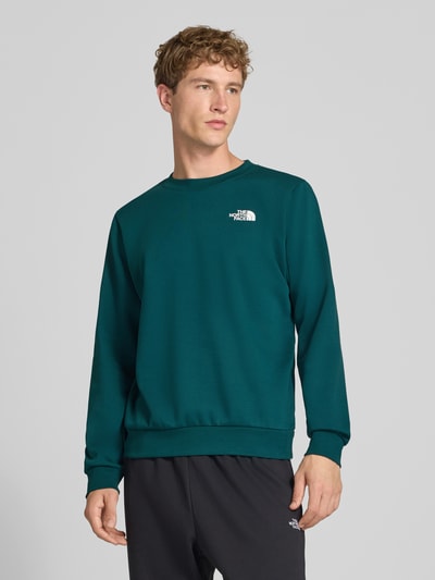 Männermodel trägt Regular fit hoodie met logodetail Model "EVOLUTION BOX" van The North Face, katoenmix, ronde hals, elastische boordjes, ruglengte maat M 62 cm, mouwlengte maat M 70 cm, ganzkörperansicht van voren.